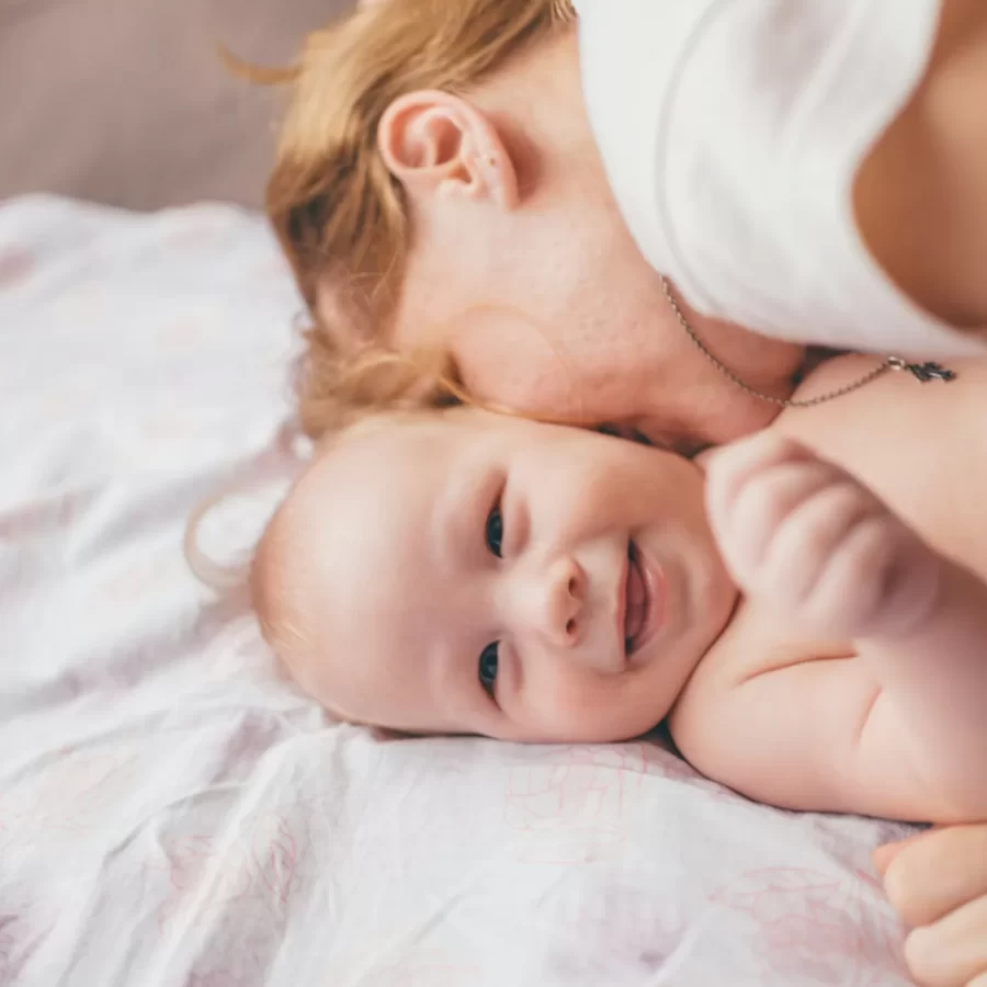 Mẹ và bé trong phòng ngủ sáng, ánh nắng chiếu qua rèm