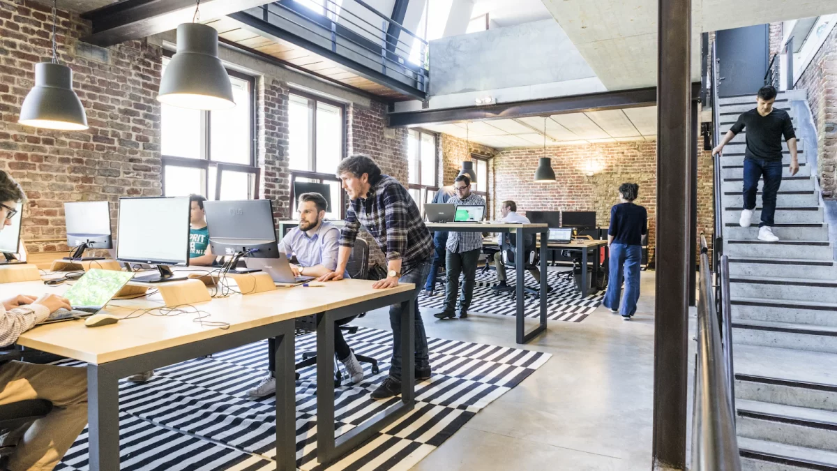 Văn phòng làm việc kiểu loft với nhóm nhân viên đang làm việc trên máy tính