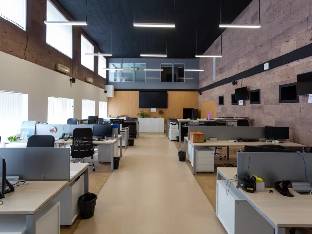 Văn phòng open space rộng rãi với nhiều bàn và máy tính