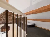 Phòng studio nhỏ với giường đơn và tường gạch mộc mạc