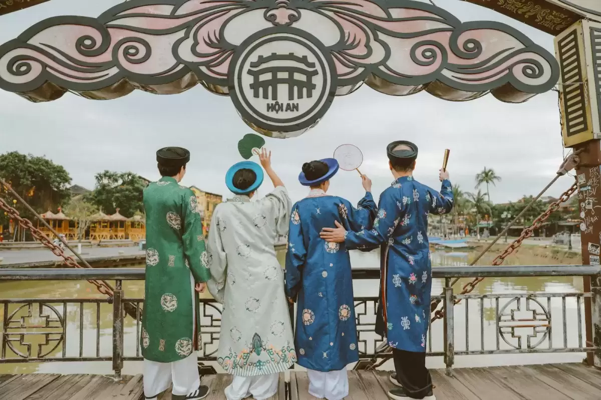 Ảnh cưới Hội An phong cách Cổ điển: nhóm bốn người mặc áo dài đứng quay lưng trên cây cầu cổ