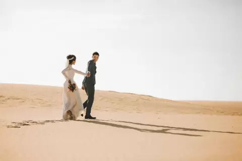 Ảnh cưới Mũi Né phong cách Ngoại cảnh: cô dâu và chú rể đứng xa nhau trên dốc cát vàng