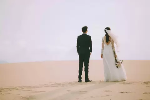 Chụp ảnh cưới Mũi Né: cô dâu chú rể đứng quay lưng trên đồi cát rộng