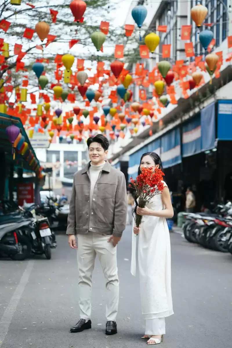 Ảnh cưới Sài Gòn phong cách Phóng sự: cặp đôi đứng giữa phố nhiều đèn lồng và biển hiệu