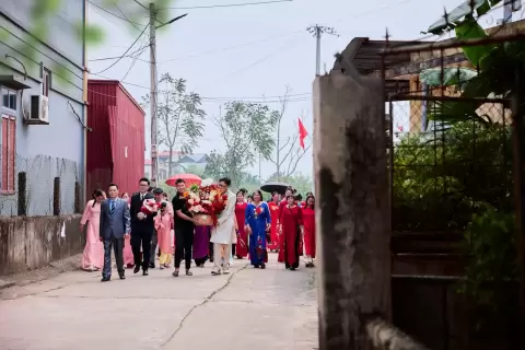 Ảnh cưới Ninh Bình phong cách Phóng sự: đoàn người áo đỏ rước lễ đi trên con đường làng