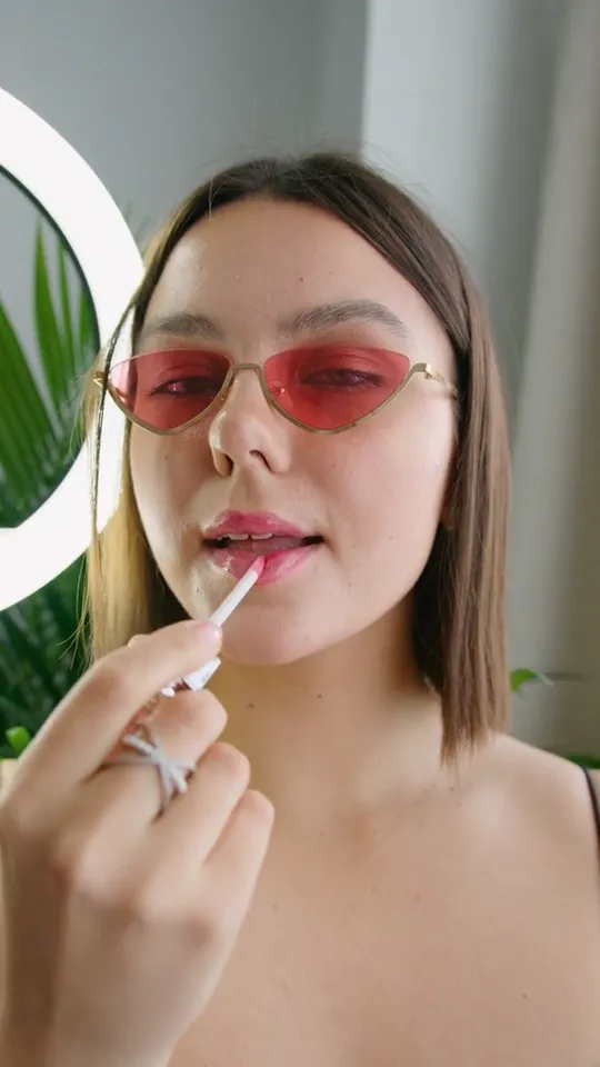 Khung hình video: Cô gái thoa son tint bóng trước gương.