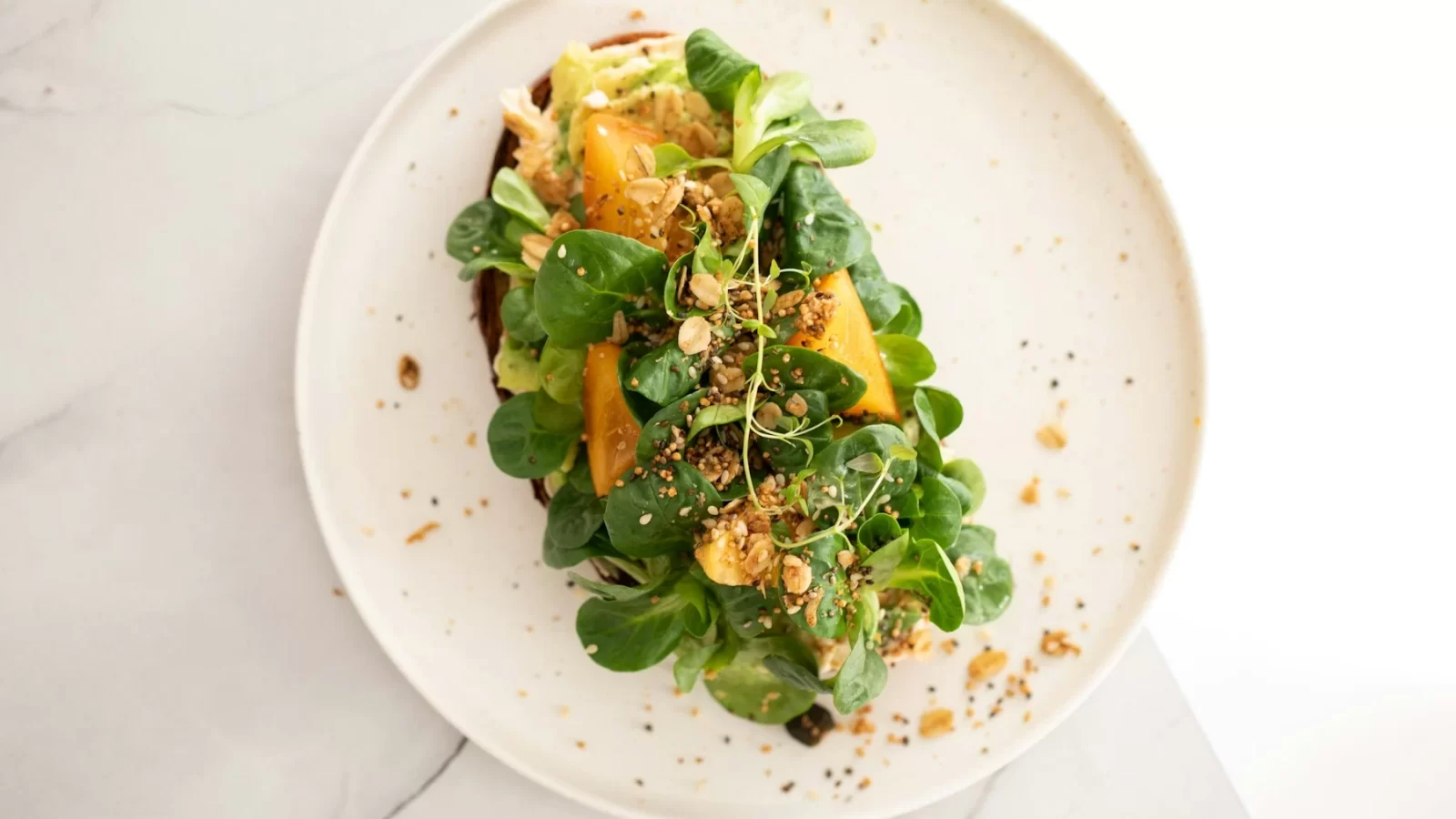 Đĩa salad rau xanh trộn cam tươi bày đẹp trên đĩa trắng