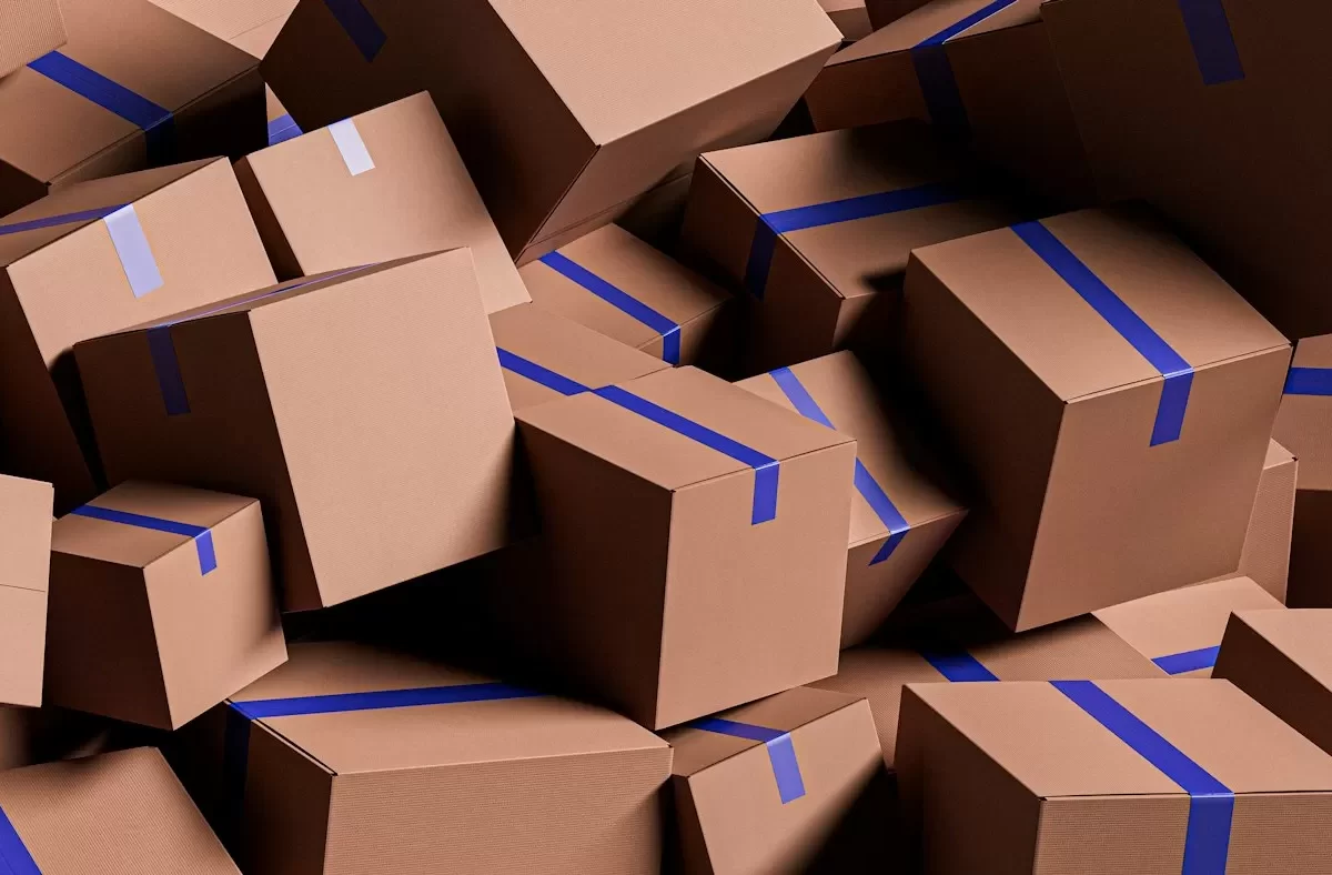 Chồng thùng carton dán băng keo xanh đã đóng gói sẵn sàng chuyển nhà