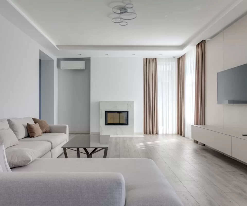 Phòng khách sáng sủa, sạch bóng với sofa màu pastel và cửa sổ lớn