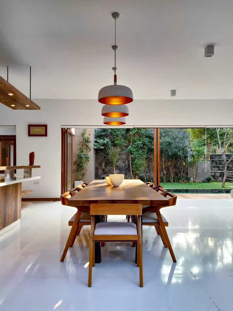 Phòng ăn với bàn gỗ dài và đèn thả trần