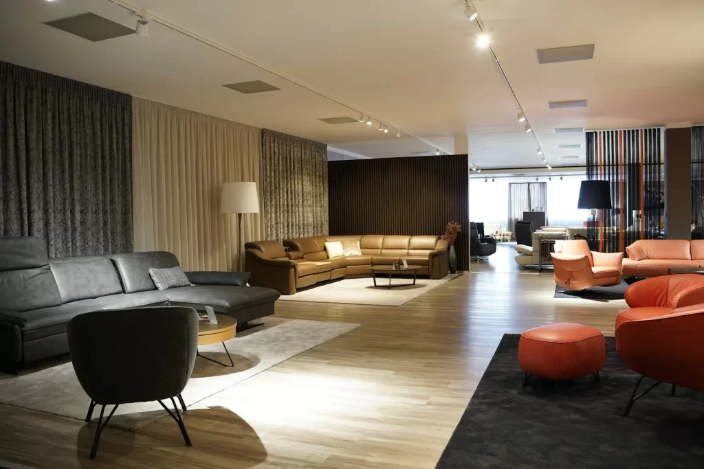 Showroom Sofa & Co. với sofa da màu cam và nâu trên sàn gỗ