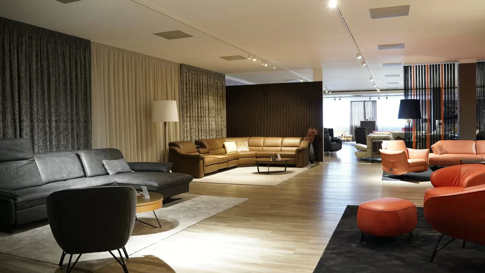 Showroom Sofa & Co. với sofa da màu cam và nâu trên sàn gỗ