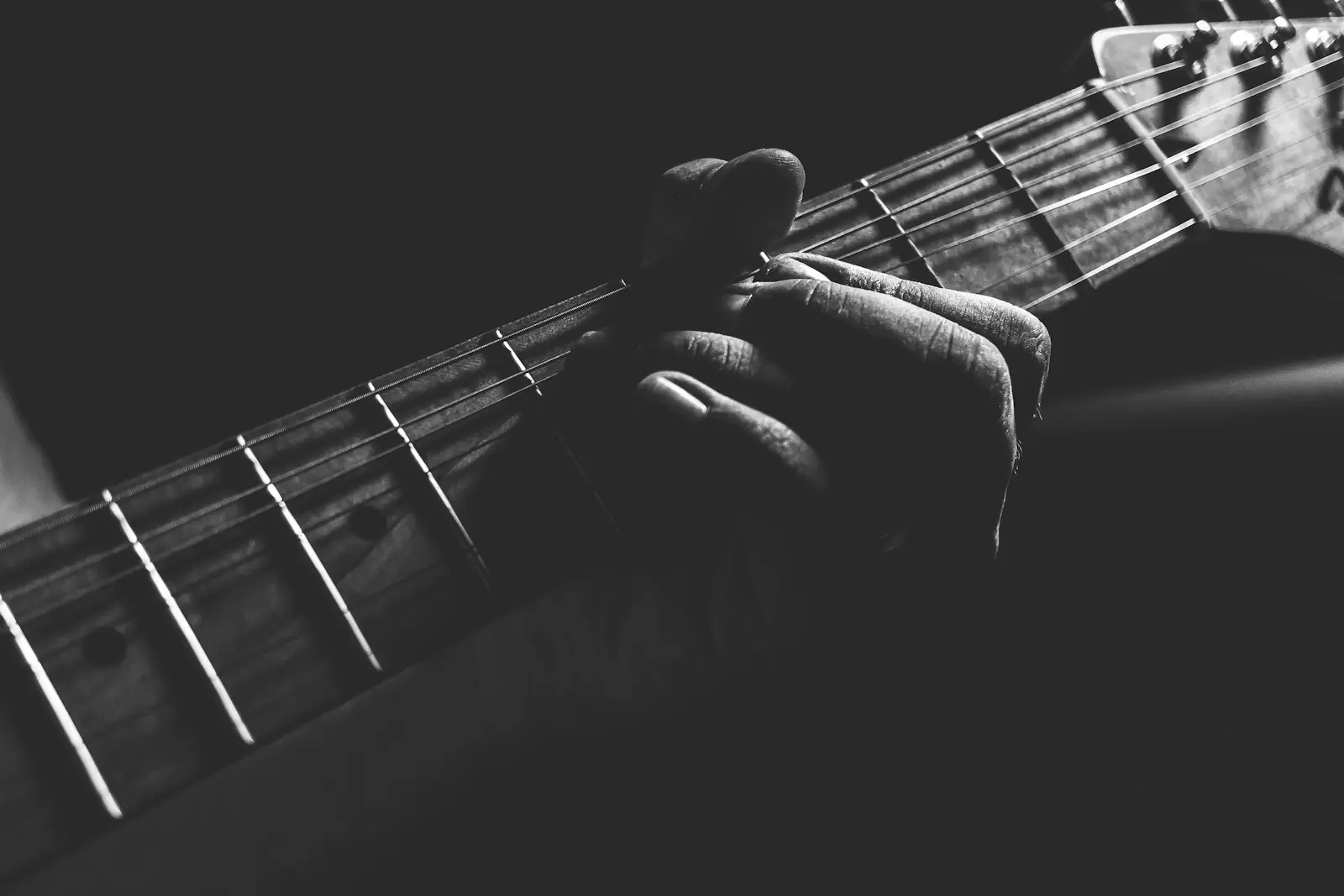 Bàn tay bấm cần đàn guitar đen trắng