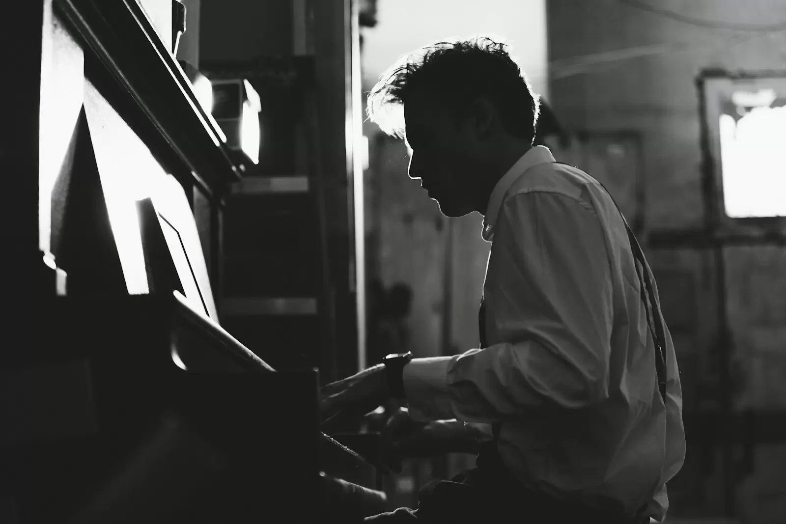 Nam nghệ sĩ nghiêng mặt chơi piano đen trắng