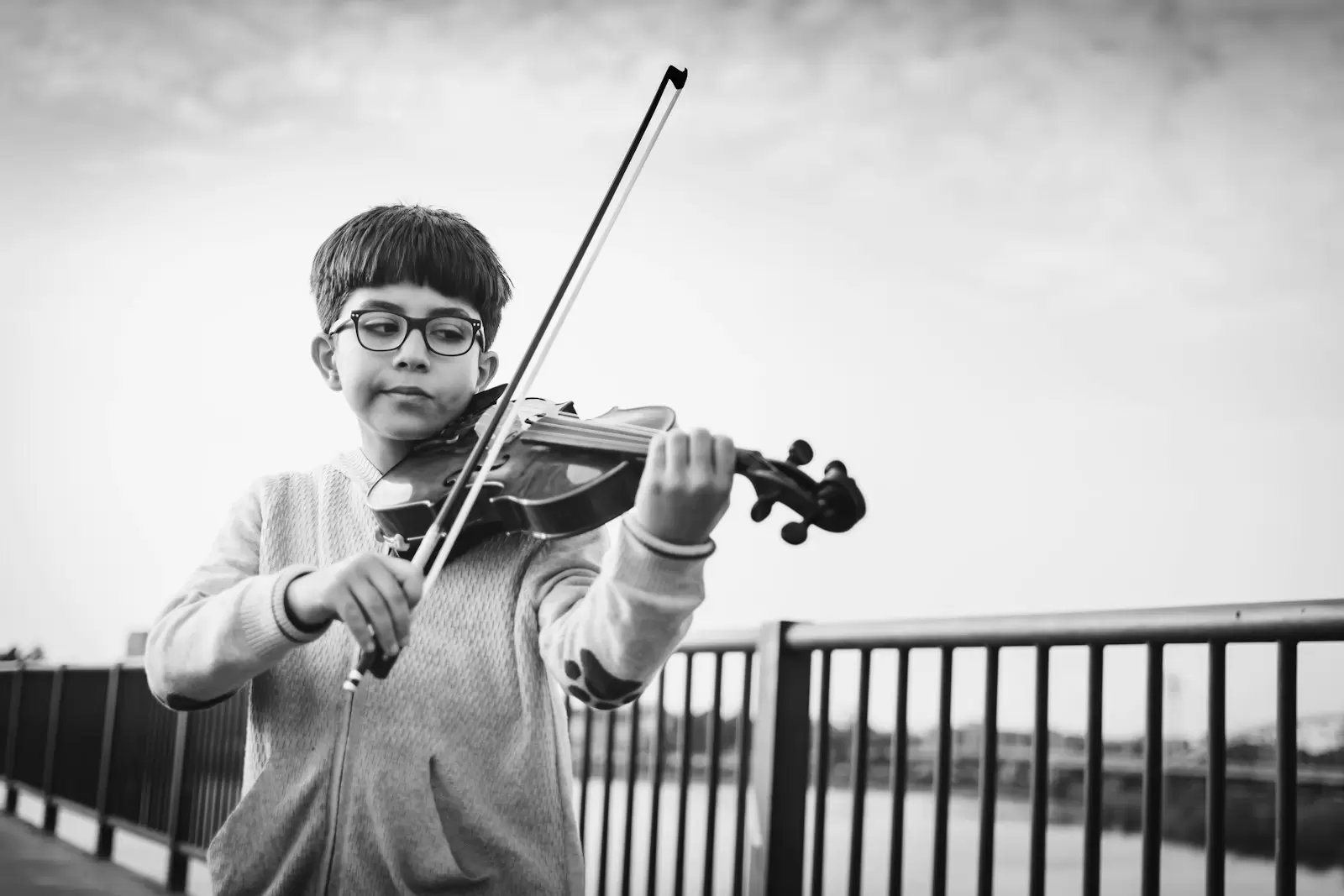 Cậu bé đeo kính đang tập kéo violin