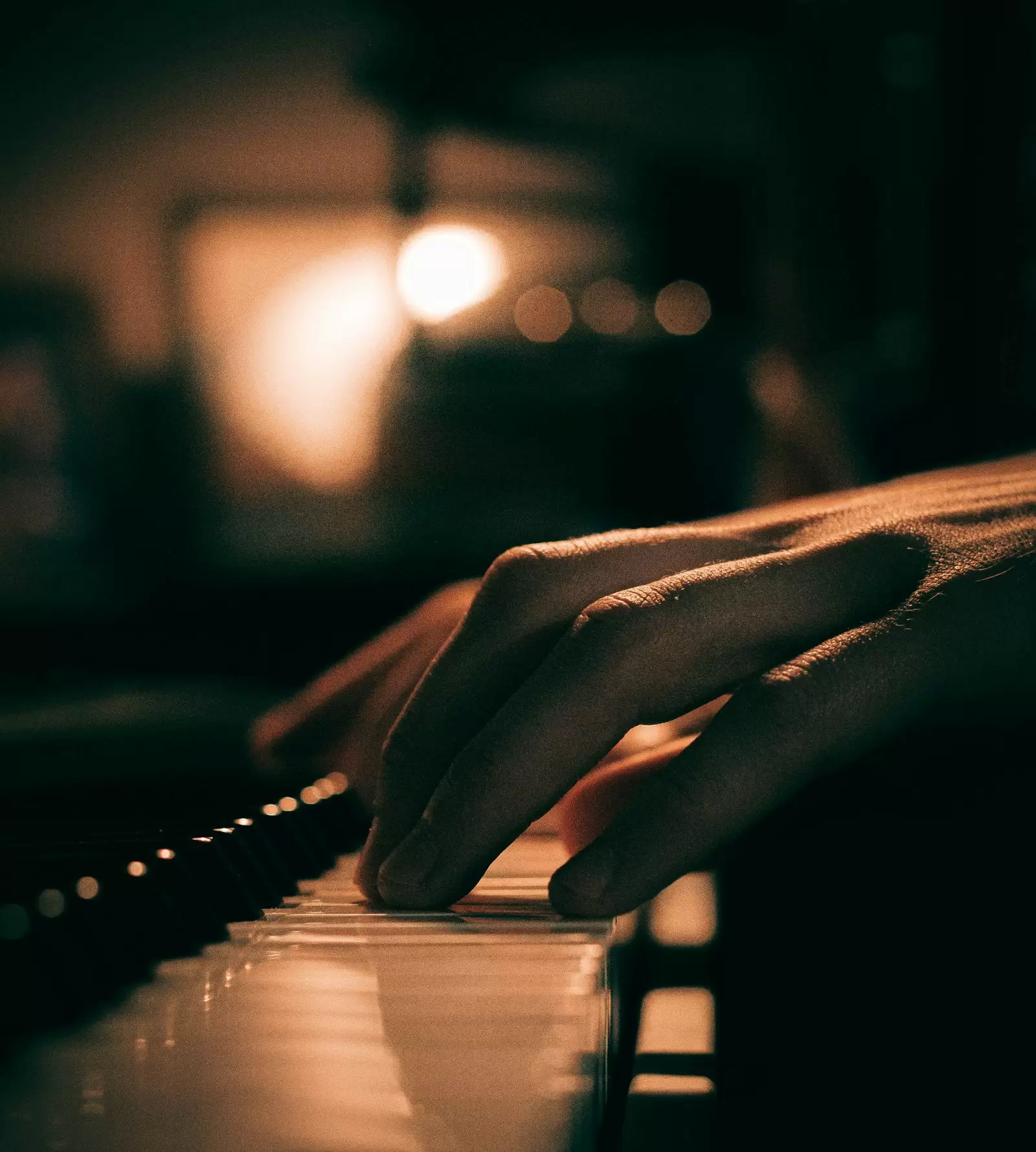 Cận cảnh bàn tay đặt trên phím đàn piano