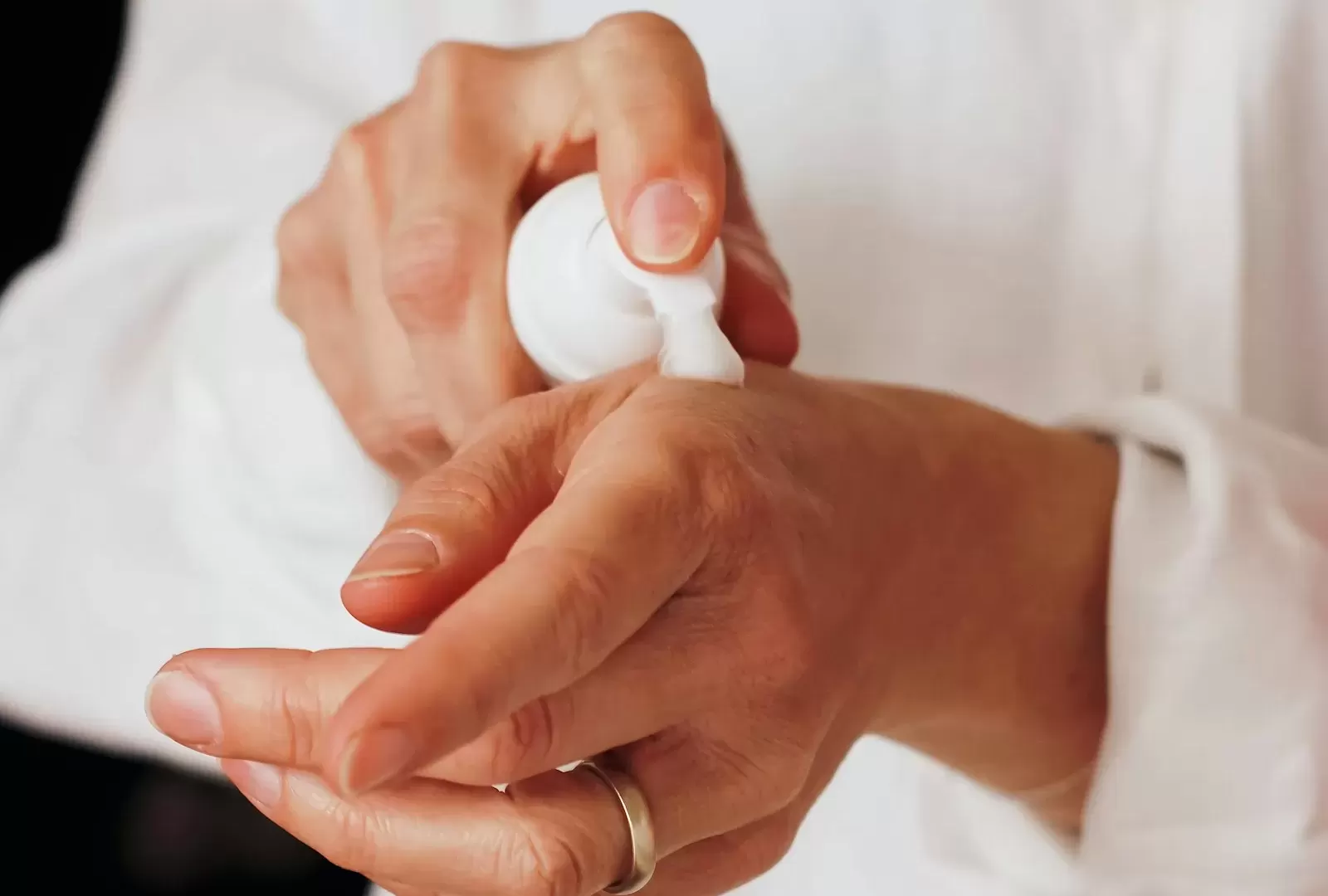 Vài chai lọ chăm sóc da đặt trên khăn bông trắng cạnh nhánh lá xanh