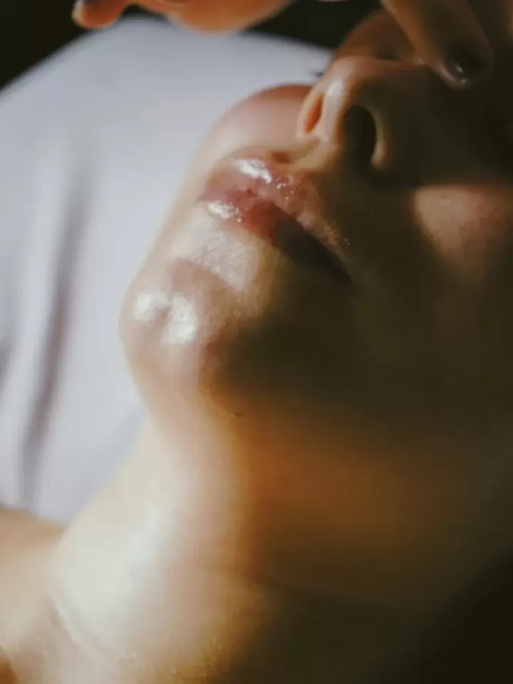 Khuôn mặt khách nhắm mắt thư giãn trong ánh sáng ấm, da căng bóng sau dưỡng ẩm