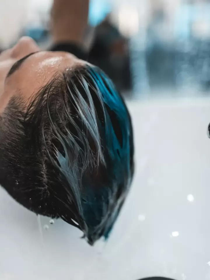 Khách nằm ngửa trên giường gội, tóc ướt chảy xuống bồn