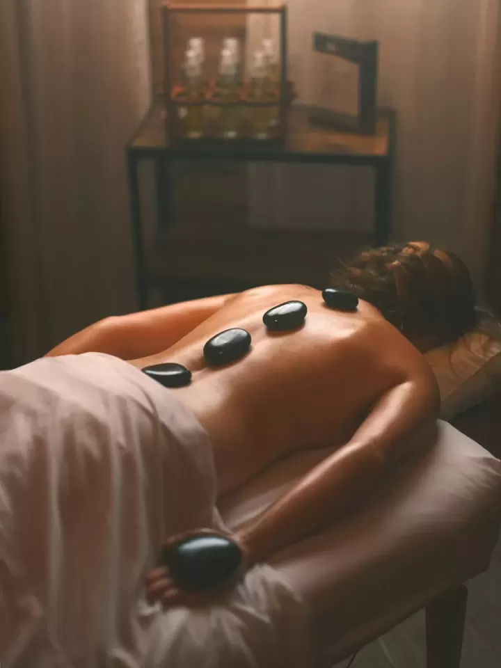Những viên đá bazan đen xếp dọc lưng khách nằm trên giường trị liệu