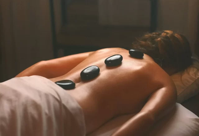 Những viên đá nóng xếp trên lưng khách đang thư giãn trong spa