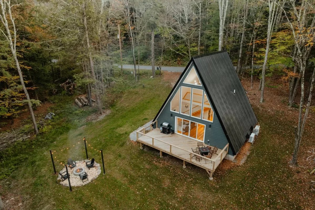 Cabin gỗ chữ A có hiên gỗ và bãi cỏ nhìn từ trên cao