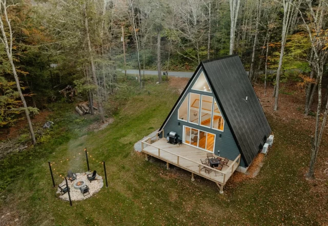 Cabin gỗ chữ A có hiên gỗ và bãi cỏ nhìn từ trên cao