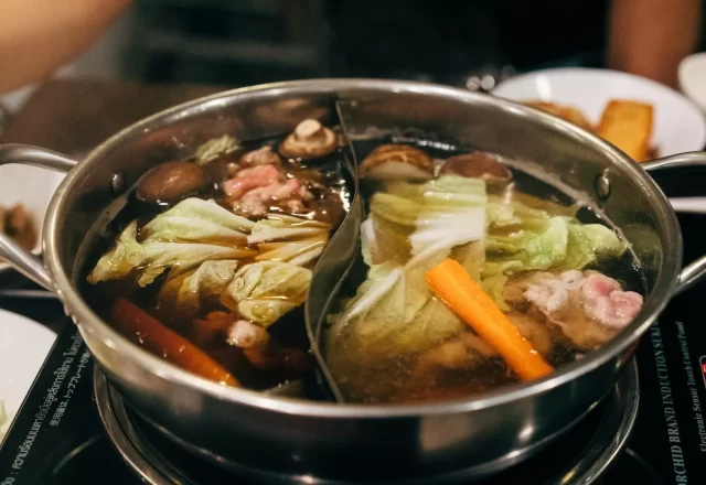 Nồi lẩu nóng đầy rau củ và thịt đang sôi