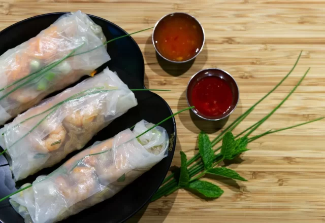 Gỏi cuốn tôm thịt và hai chén nước chấm trên khay gỗ