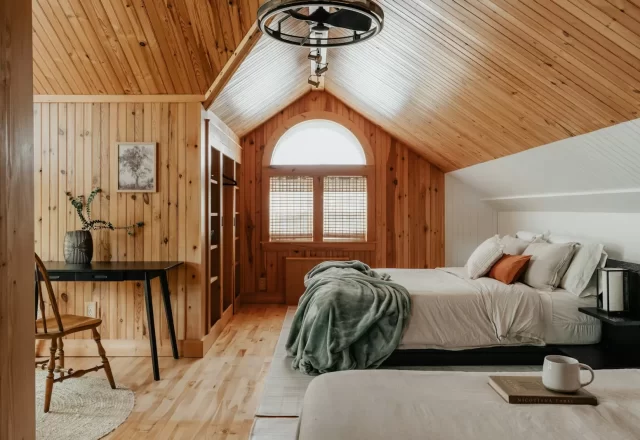 Phòng ngủ gác mái ốp gỗ sáng ấm với cửa sổ vòm