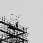 Công nhân đứng trên giàn giáo nóc nhà