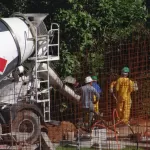 Kỹ thuật viên đứng cạnh máy bơm bê tông