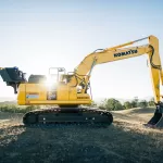 Máy xúc đào vàng đỗ trên bãi đất