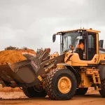 Máy xúc lật vàng đen trên bãi đất nâu
