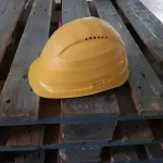 Mũ bảo hộ vàng đặt trên pallet gỗ