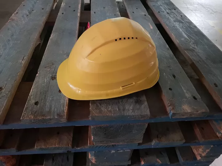 Mũ bảo hộ vàng đặt trên pallet gỗ