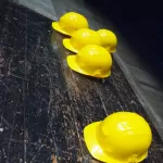 Năm mũ bảo hộ vàng trên nền xám