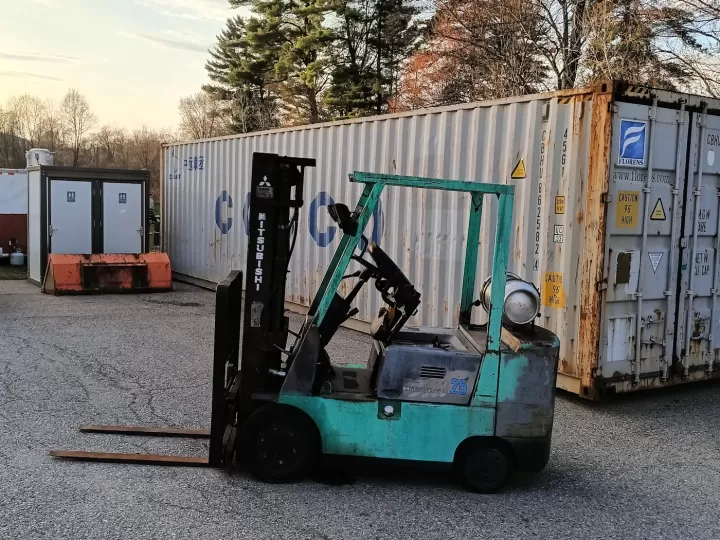 Xe nâng xanh ngọc đỗ trước bãi container