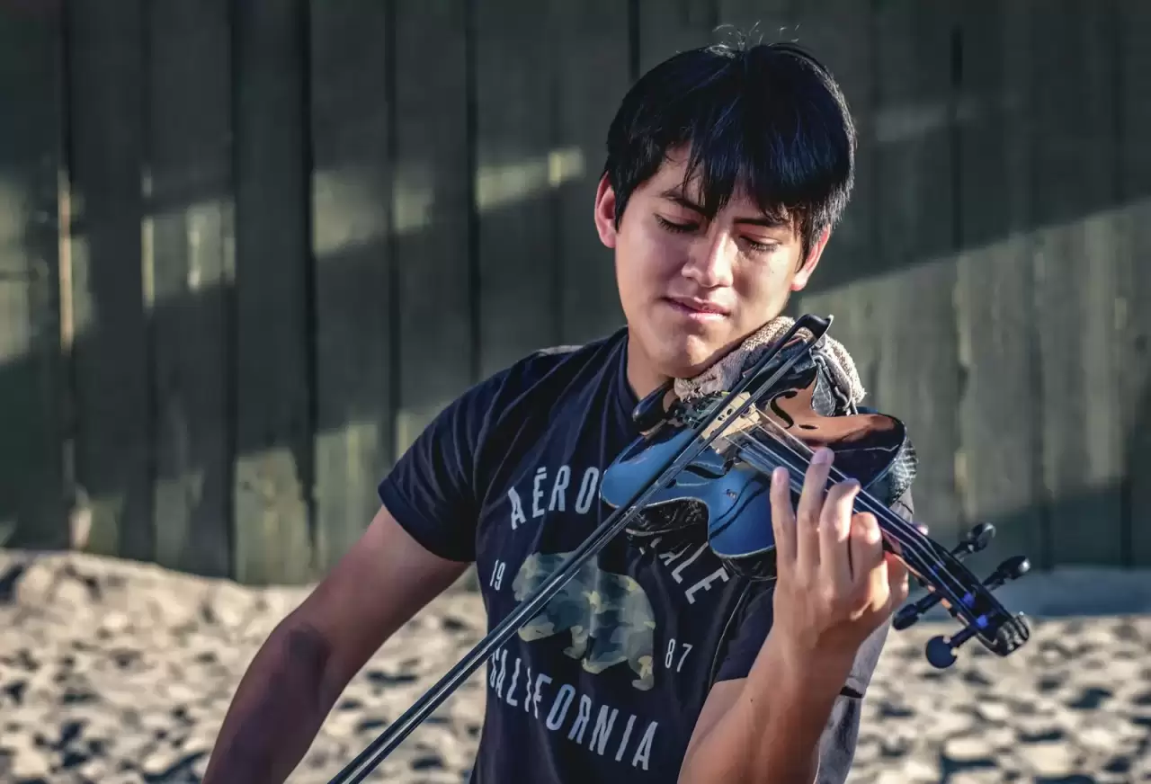 Nam nghệ sĩ trẻ áo xanh đang chơi violin