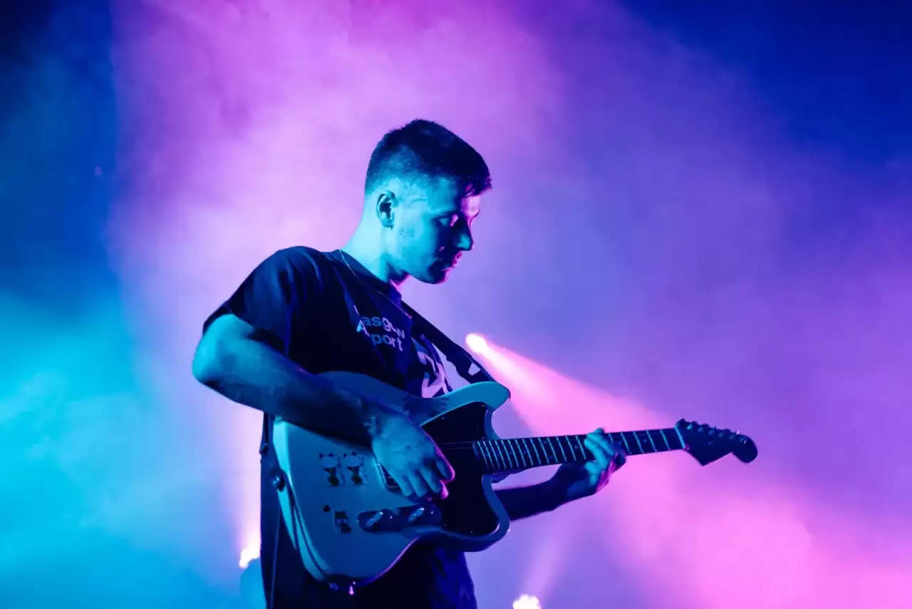 Nam nghệ sĩ áo đen biểu diễn guitar điện