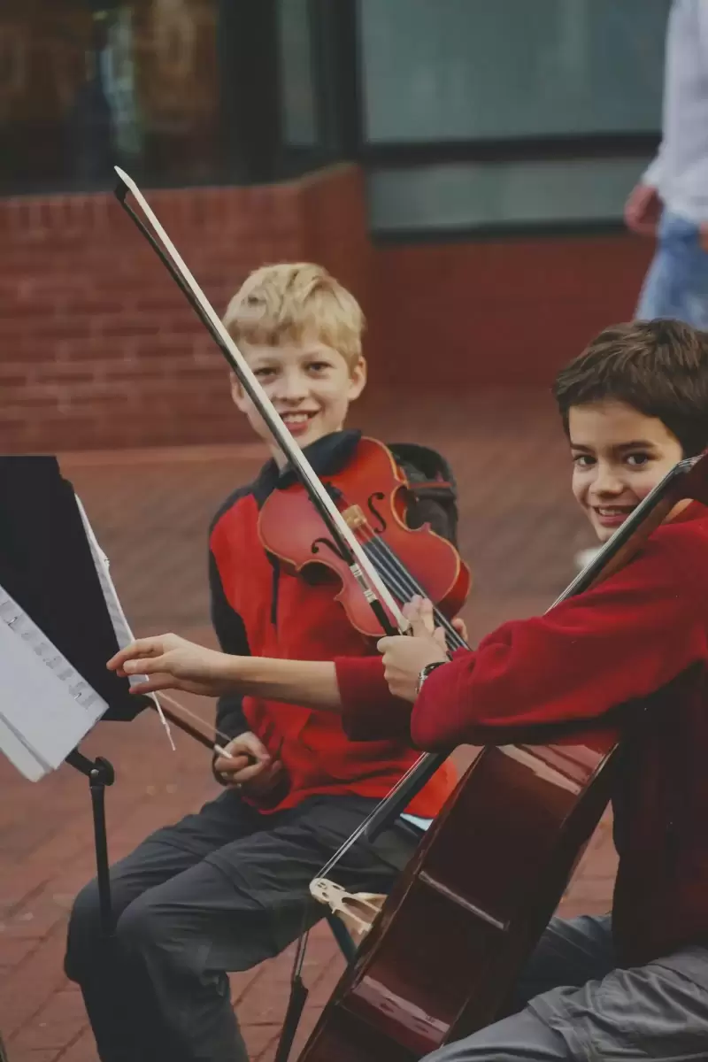 Cậu bé áo đỏ đang kéo violin