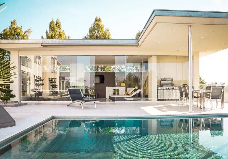 Biệt thự tường kính bên hồ bơi ngày nắng
